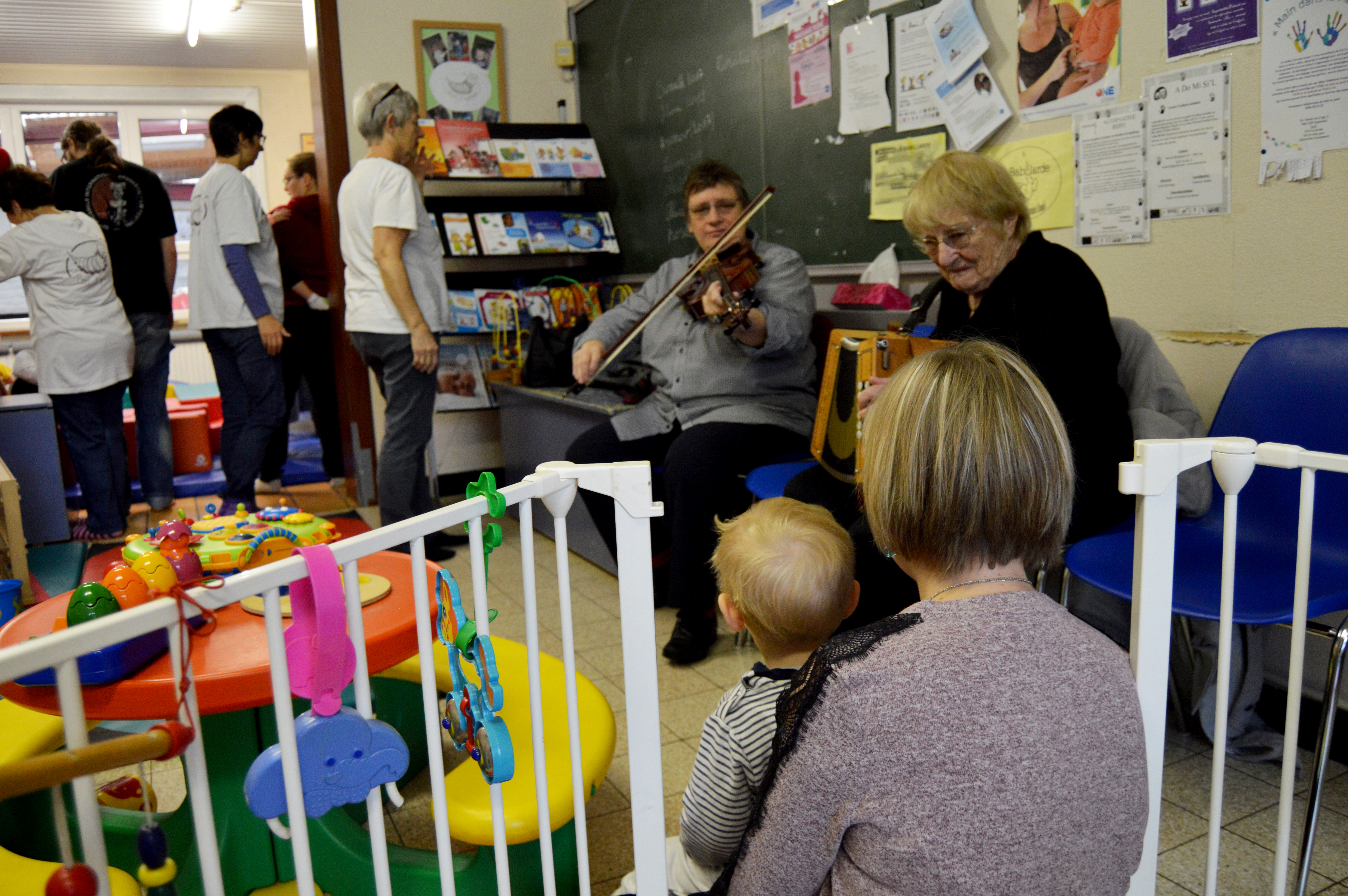 Un enfant et sa maman en train de regarder les deux musiciennes jouer.