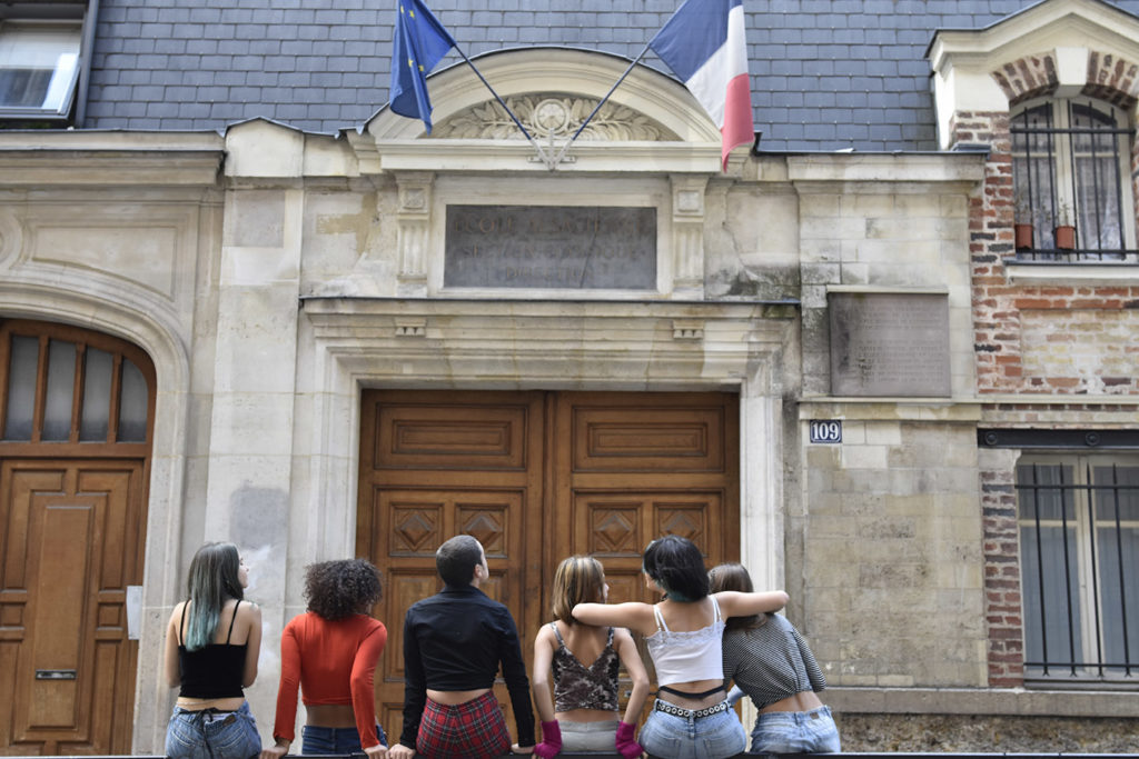 Lycéen.es assis ensemble devant le lycée Notre dame des champs
