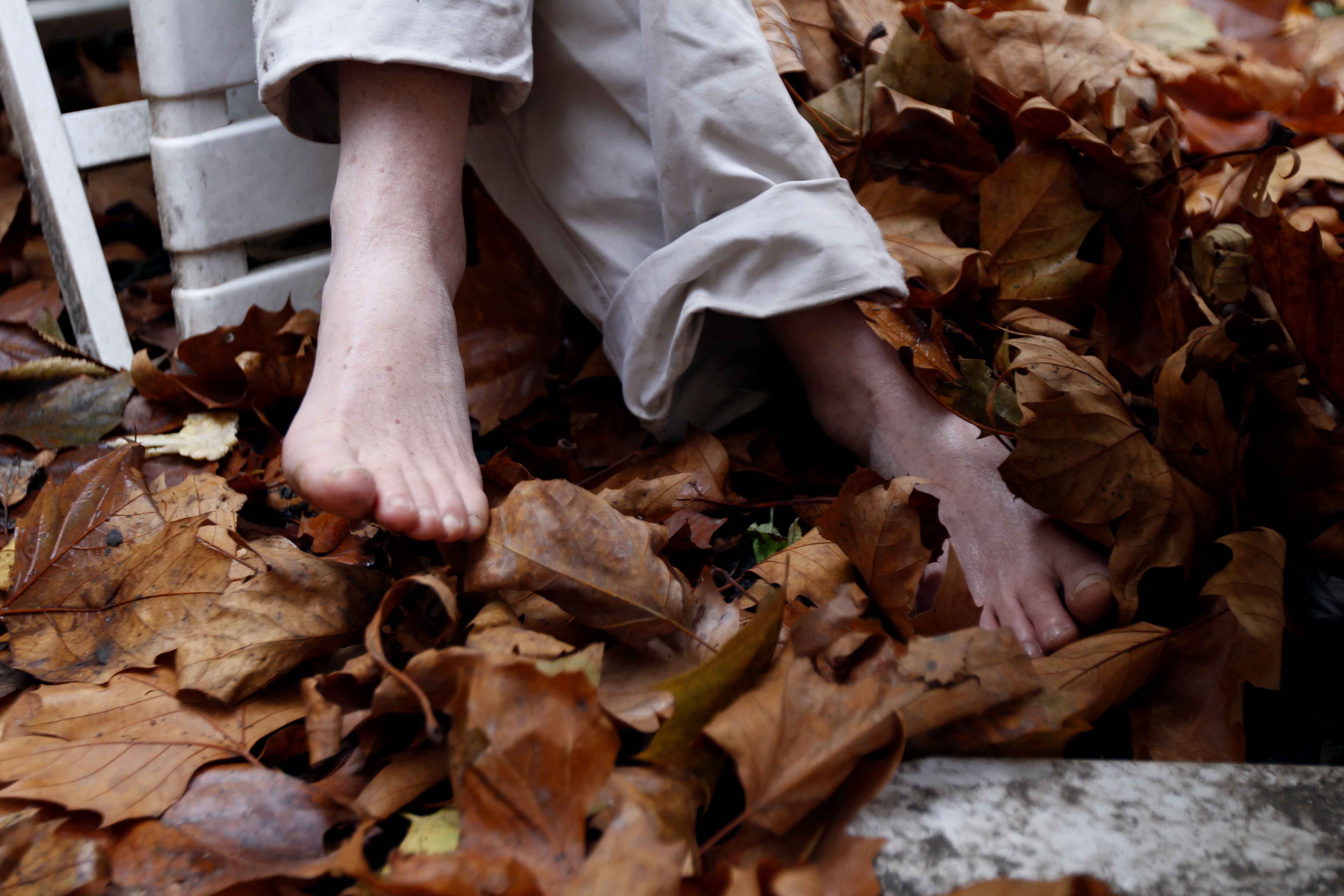 Pieds de Kristien dans les feuilles mortes de son jardin