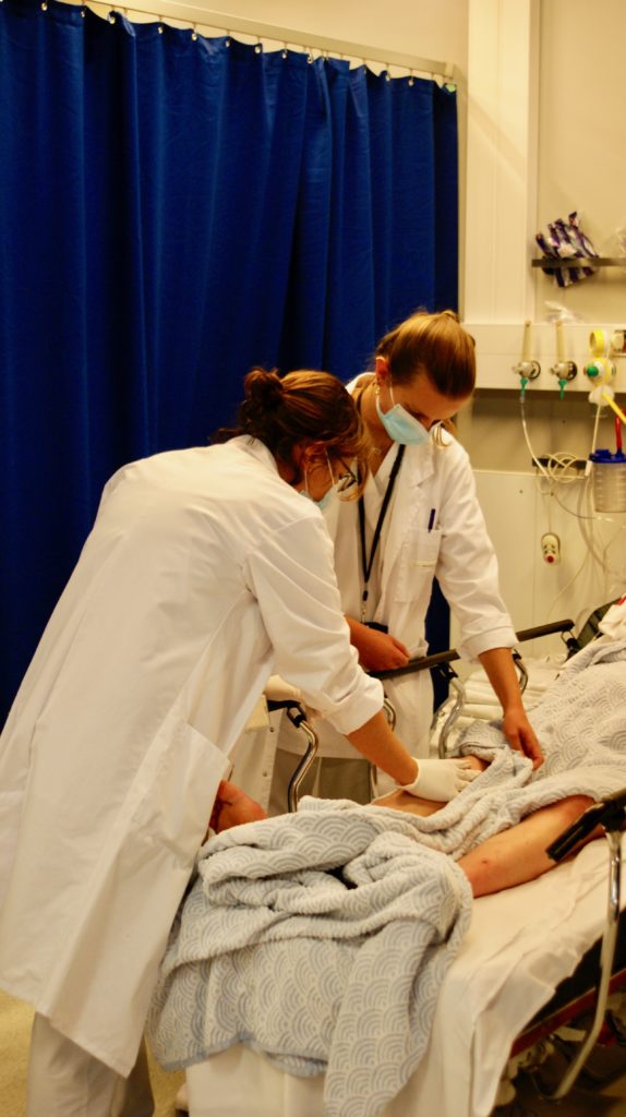 Une urgentiste et une interne examine les genoux du patient