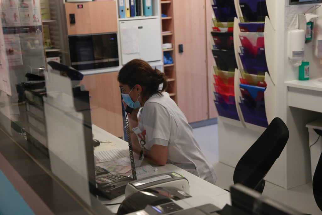 Sage-femme assise à son bureau, au téléphone. 