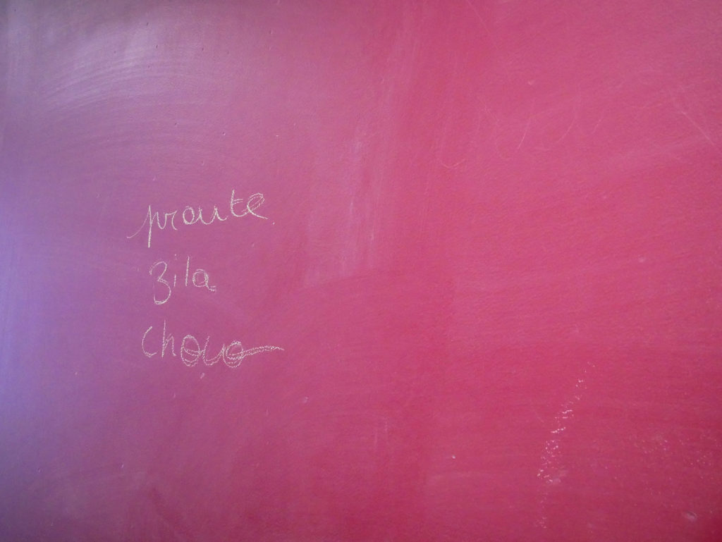 inscriptions sur un mur rose "proute zila choco"
