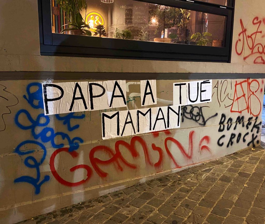 Slogan :" Papa a tué Maman" sur le mur d'un café.