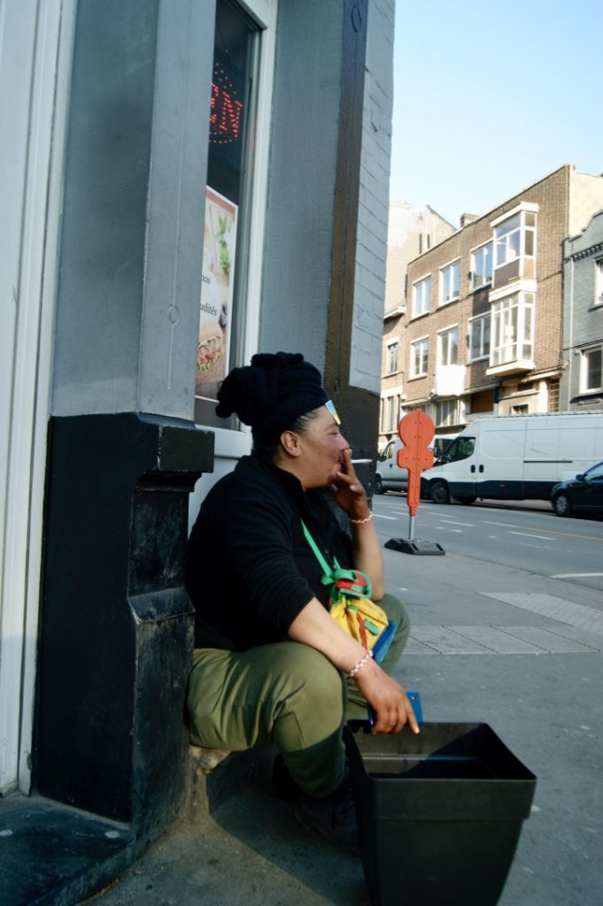 une femme, cigarette à la main, regarde au loin