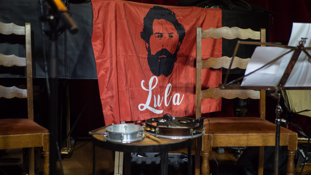 Un drapeau de Lula est suspendu derrière les musiciens. .