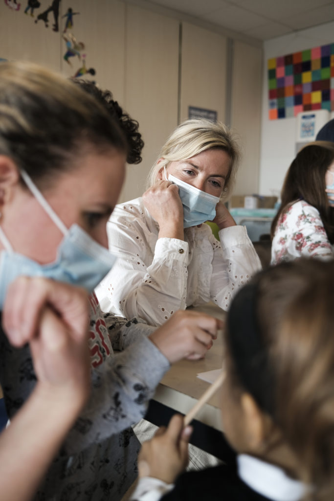 Institutrice écoutant une enfant parler.