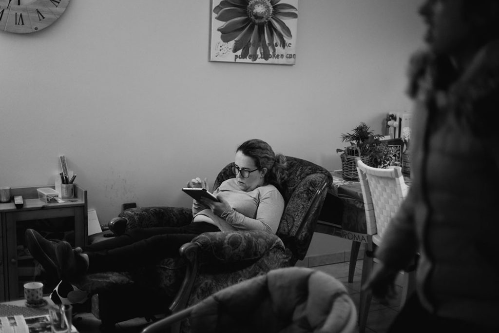 Marie, assise dans son fauteuil, joue sur son iPad.