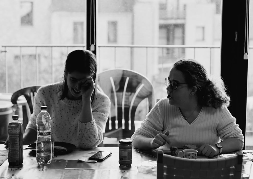 Chloé et Marie sont pliées de rire à table.