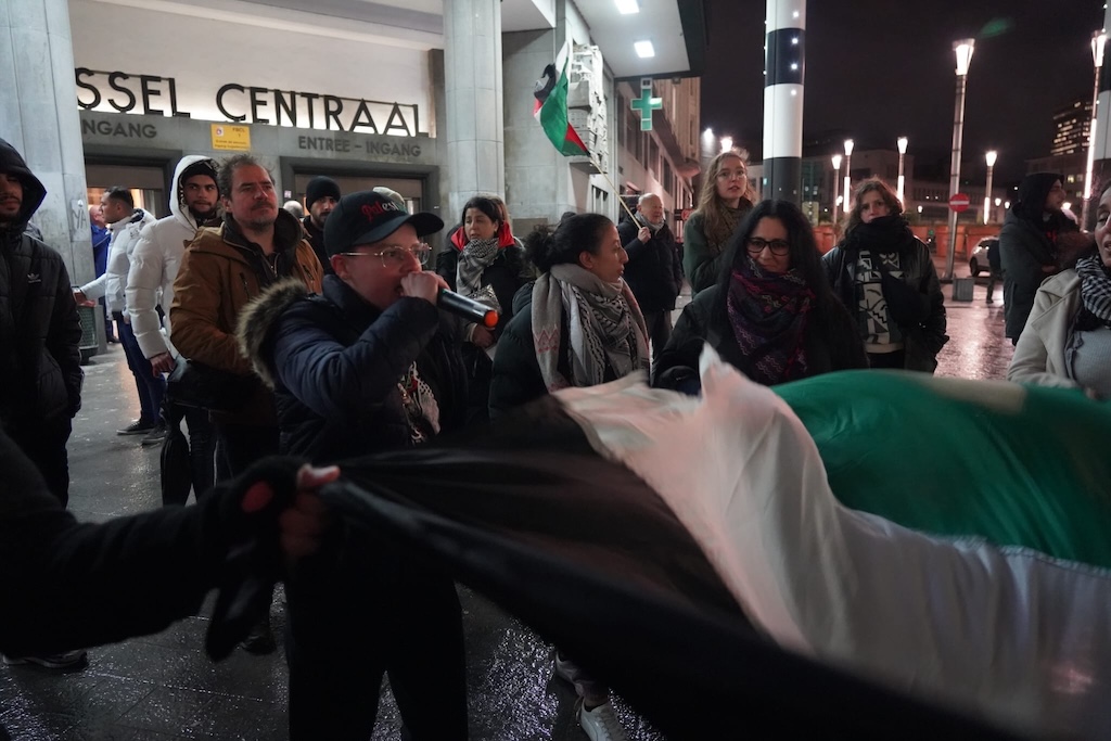 Dalila lance les slogans au micro devant le long drapeau palestinien, devant la Gare Centrale