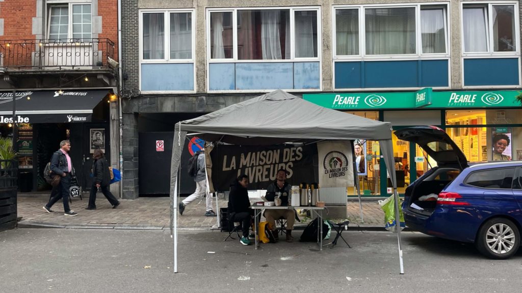 Les installations sont rudimentaires, avec une tente ouverte et un coffre de voiture pour s’abriter. 